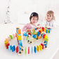 Two children playing with a colorful wooden toy set on a white surface.