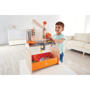 Child playing with a toy workshop set in a living room
