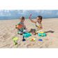 Two children playing with beach toys on a sandy beach with ocean in the background