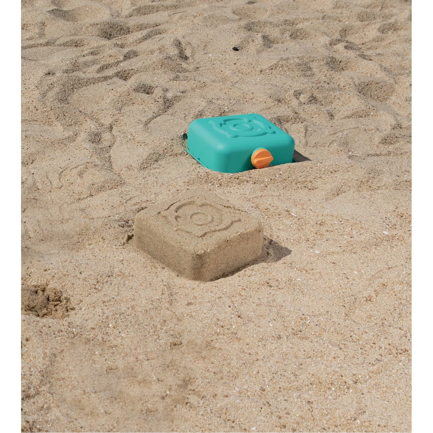 Toy sandcastle mold on a sandy surface