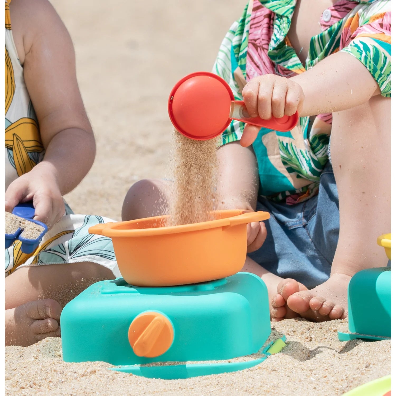 Children playing with sand toys on a sandy beach