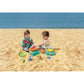 Two children playing with colorful sand toys on a sandy beach.