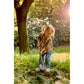 Child playing with a shovel in a grassy area with trees