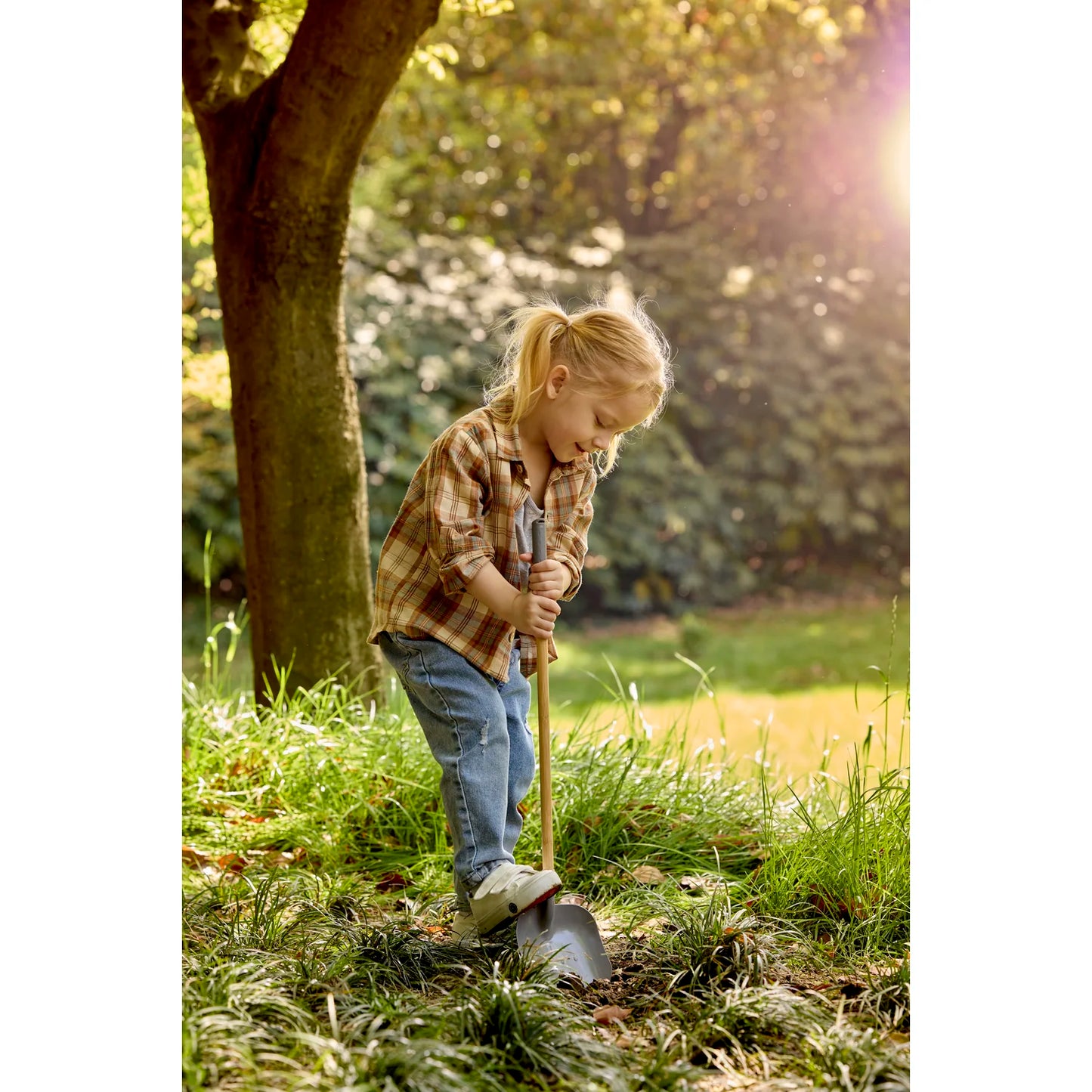 Child with a shovel in a garden setting