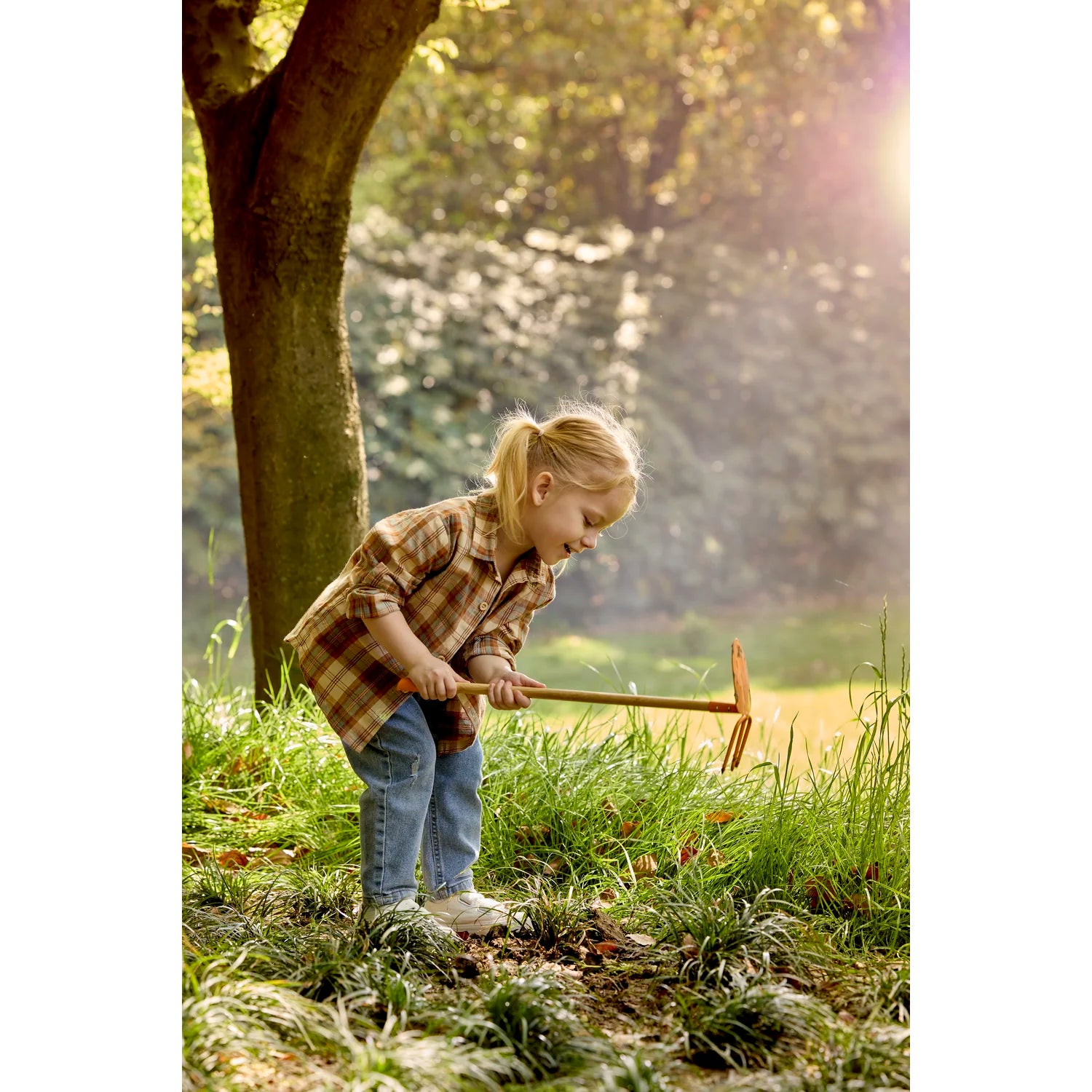 Child playing with a toy hammer in a natural setting