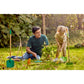 Man and child gardening together in a park with gardening tools around them.
