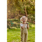 Child holding a garden rake in a grassy outdoor setting