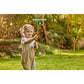 Child holding a garden rake in a grassy outdoor setting