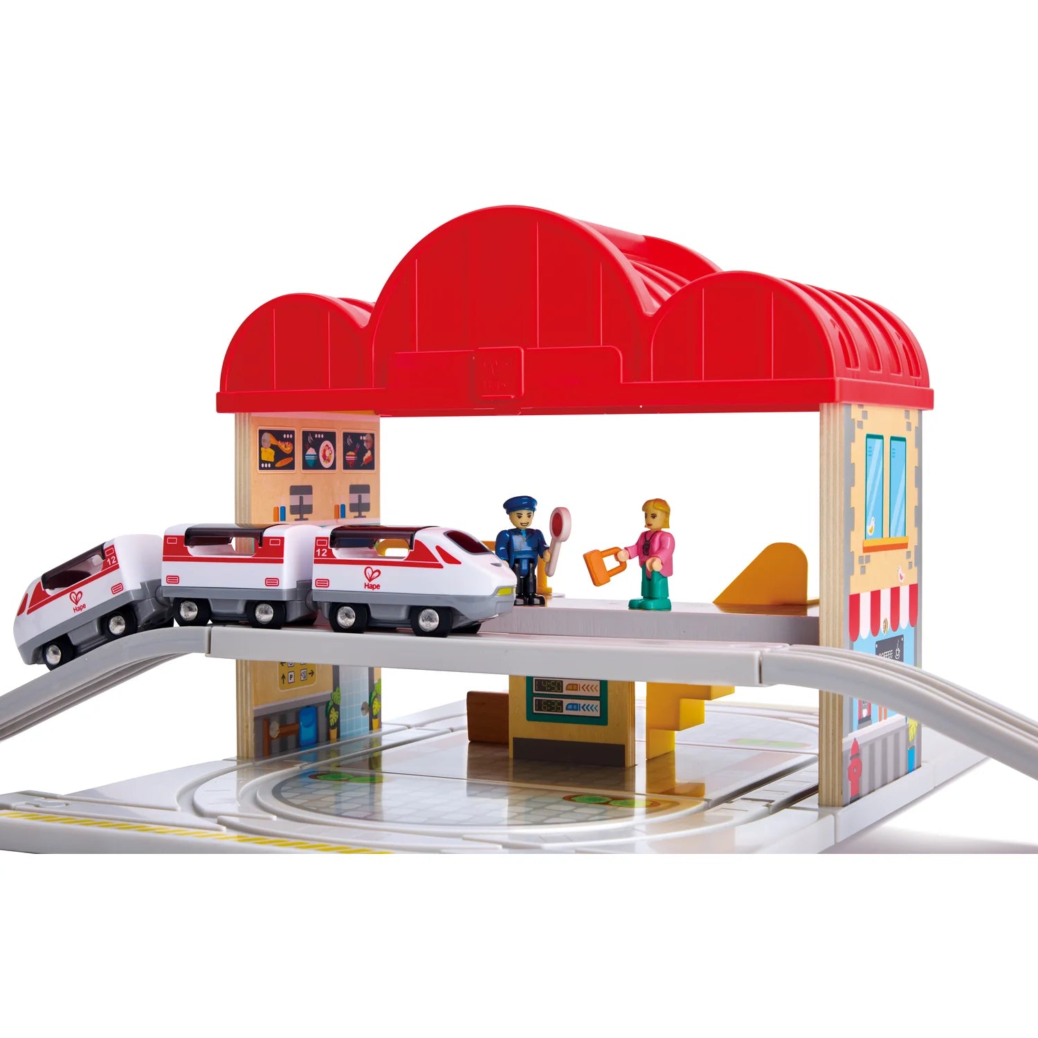 Toy train set with a red roofed building and toy figures on a white background