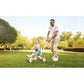 Man pushing a child on a tricycle in a park