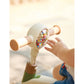 Child's hand interacting with a colorful toy held by an adult, with a warm glow in the background.