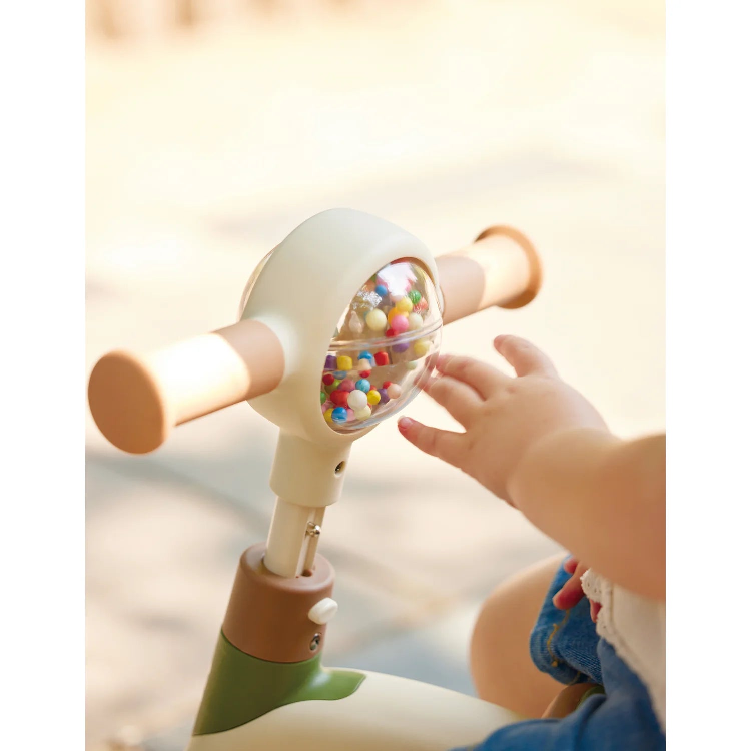 Child's hand interacting with a colorful toy held by an adult, with a warm glow in the background.