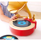 Toy record player with a child's hand interacting with it on a white surface.