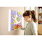 Child interacting with a colorful magnetic drawing board on a wall.