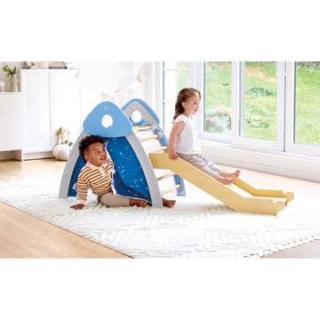 Two children playing on a blue and yellow slide indoors.