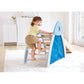Child climbing on a blue and wooden slide in a room with white walls and a window.