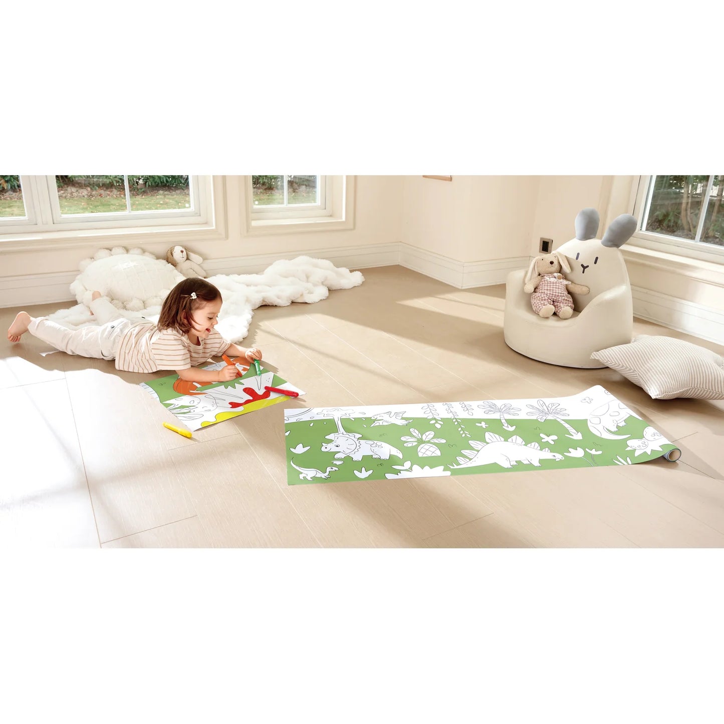 Child playing with a green mat in a room with soft furniture and large windows.
