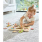 Child playing with a wooden puzzle on a carpeted floor.