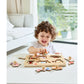 Child playing with a wooden puzzle toy in a bright room.