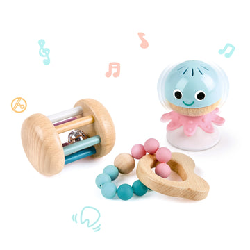 A set of colorful baby toys including a rolling rattle, a stay-put rattle attached to a white suction cup, and a chewy teether beads toy.