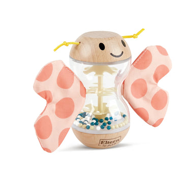 A colorful toy resembling a butterfly with wooden body and fabric wings, with beads inside the body creating a rainmaker effect.