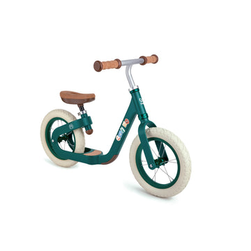 A green Hape balance bike with cork handle grips and a wooden seat, designed for young children.