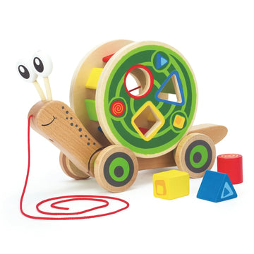 A wooden snail-shaped toy with a shell containing colorful shape sorter blocks, attached to a red pull string.
