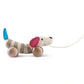 A soft fabric dog toy on wheels with wooden components, featuring rotatable ears and a pull-along string.