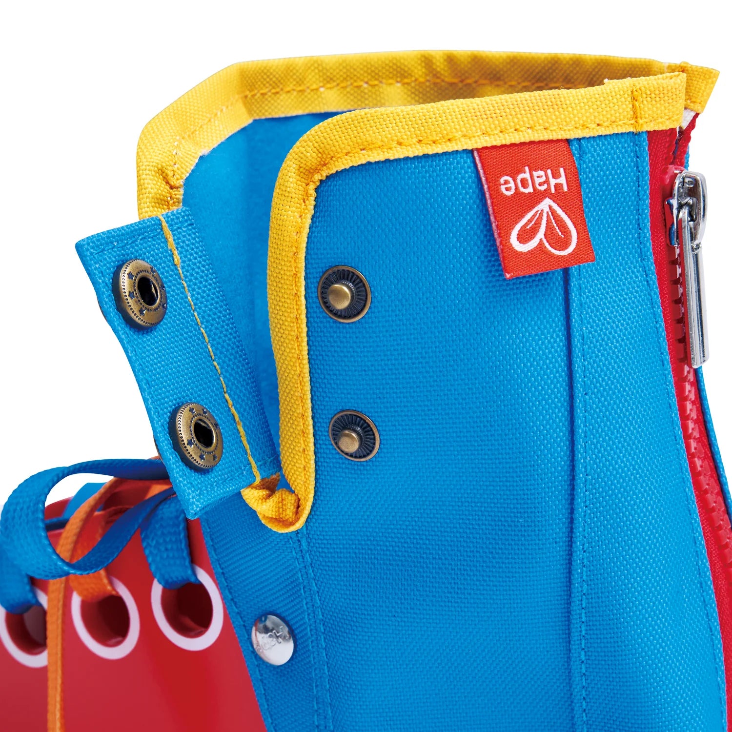 Close-up of a blue bag with yellow trim and a red Hape logo tag.