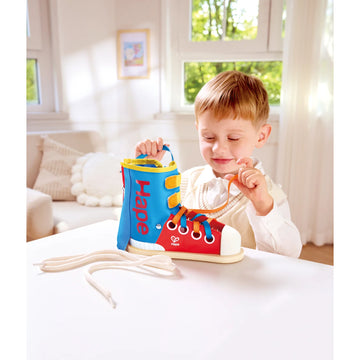 Child playing with a colorful toy shoe in a bright room