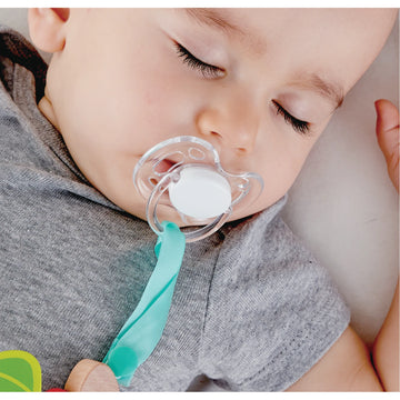 Baby sleeping with a pacifier in its mouth