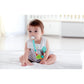 Baby sitting on a bed with a pacifier and colorful toy