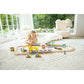 Child playing with a toy train set on a carpeted floor