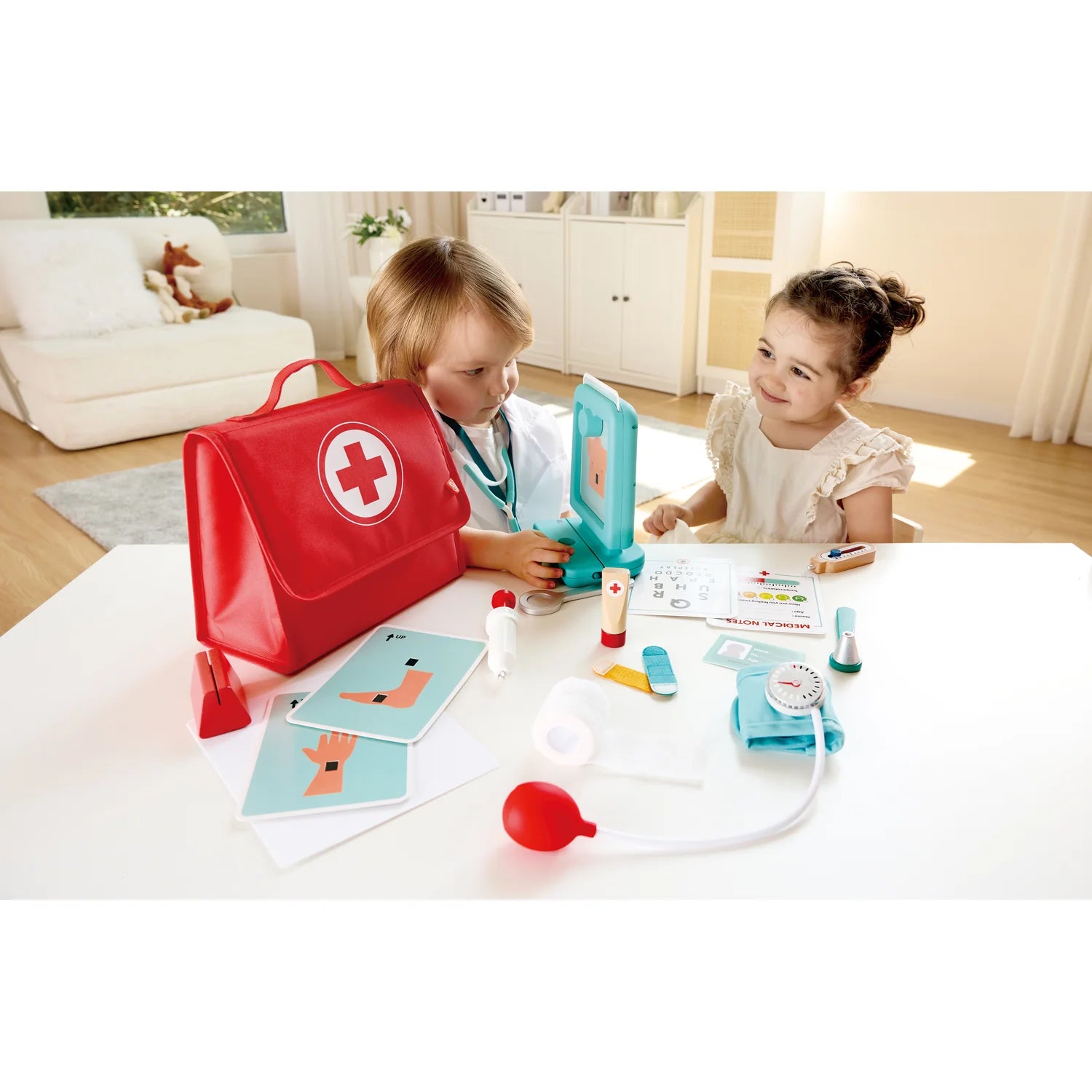 Two children playing with a toy medical set on a table.