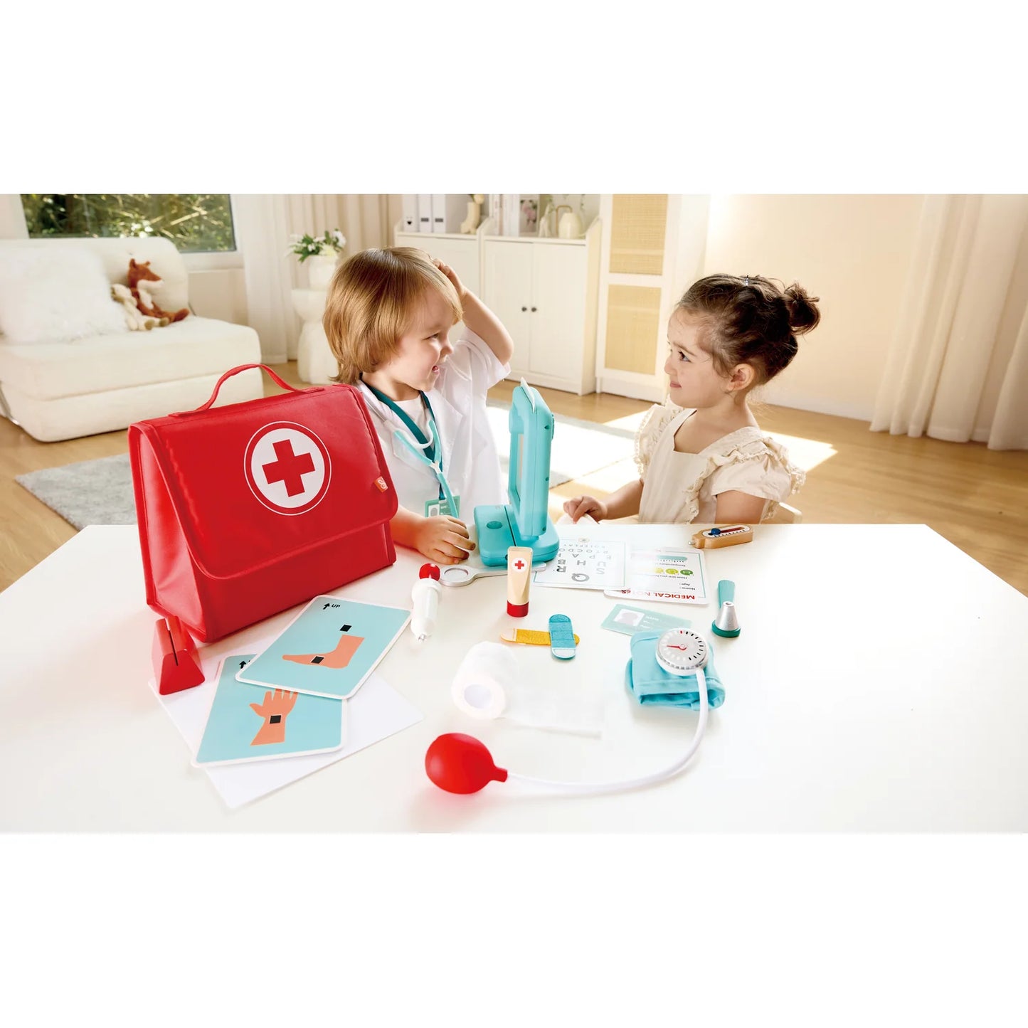 Two children playing with a toy medical set on a table in a living room.