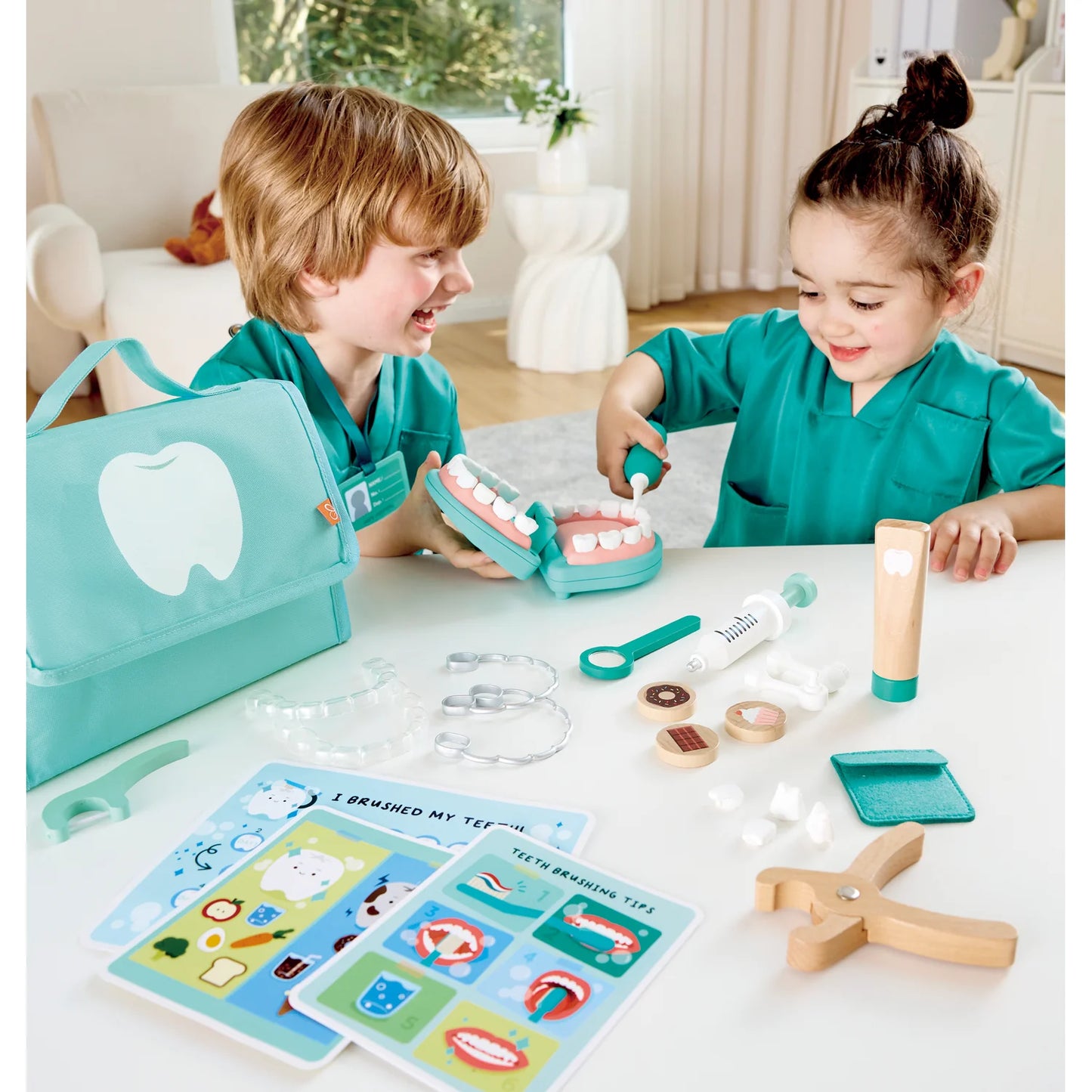 Two children playing with a dental-themed toy set on a table.