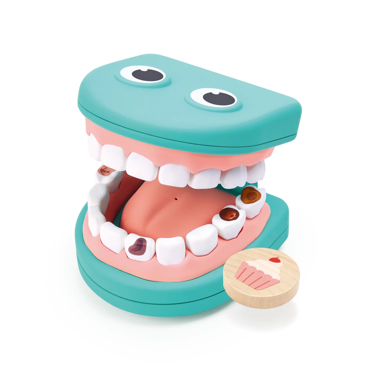 Toy mouth with open jaws and a small cupcake-shaped object on a white background