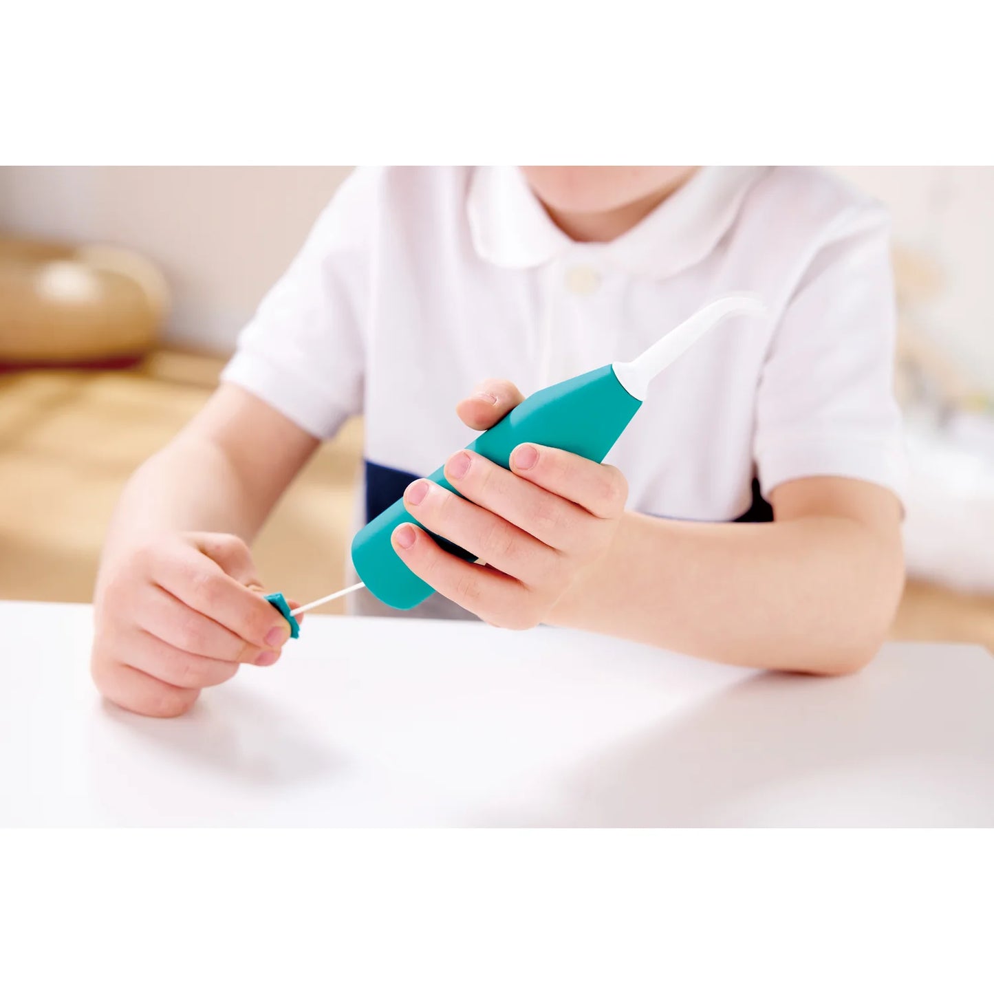 Child using a teal toy syringe with a white background
