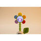 Colorful flower-shaped toy with a smiling face on a beige background