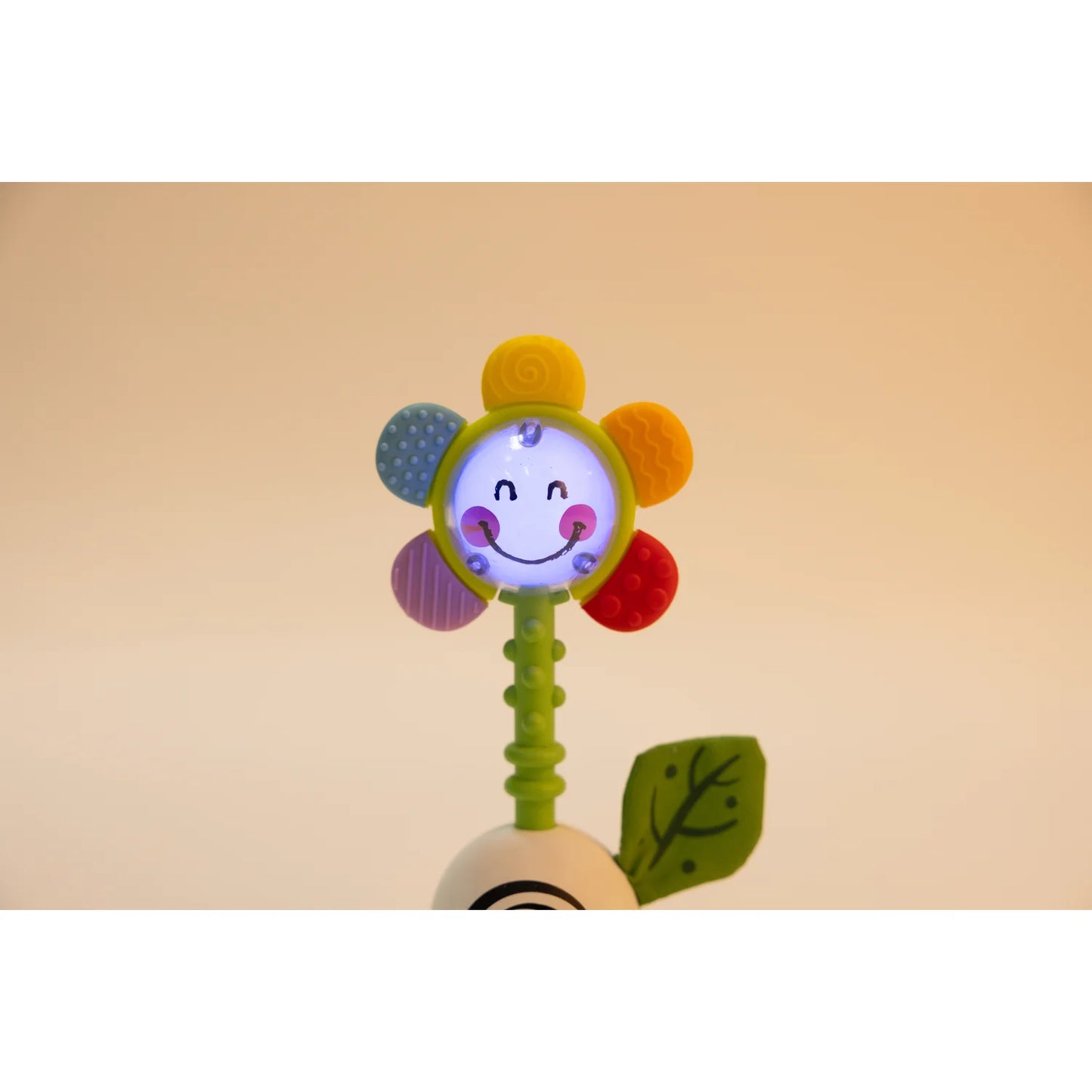 Colorful flower-shaped toy with a smiling face on a beige background