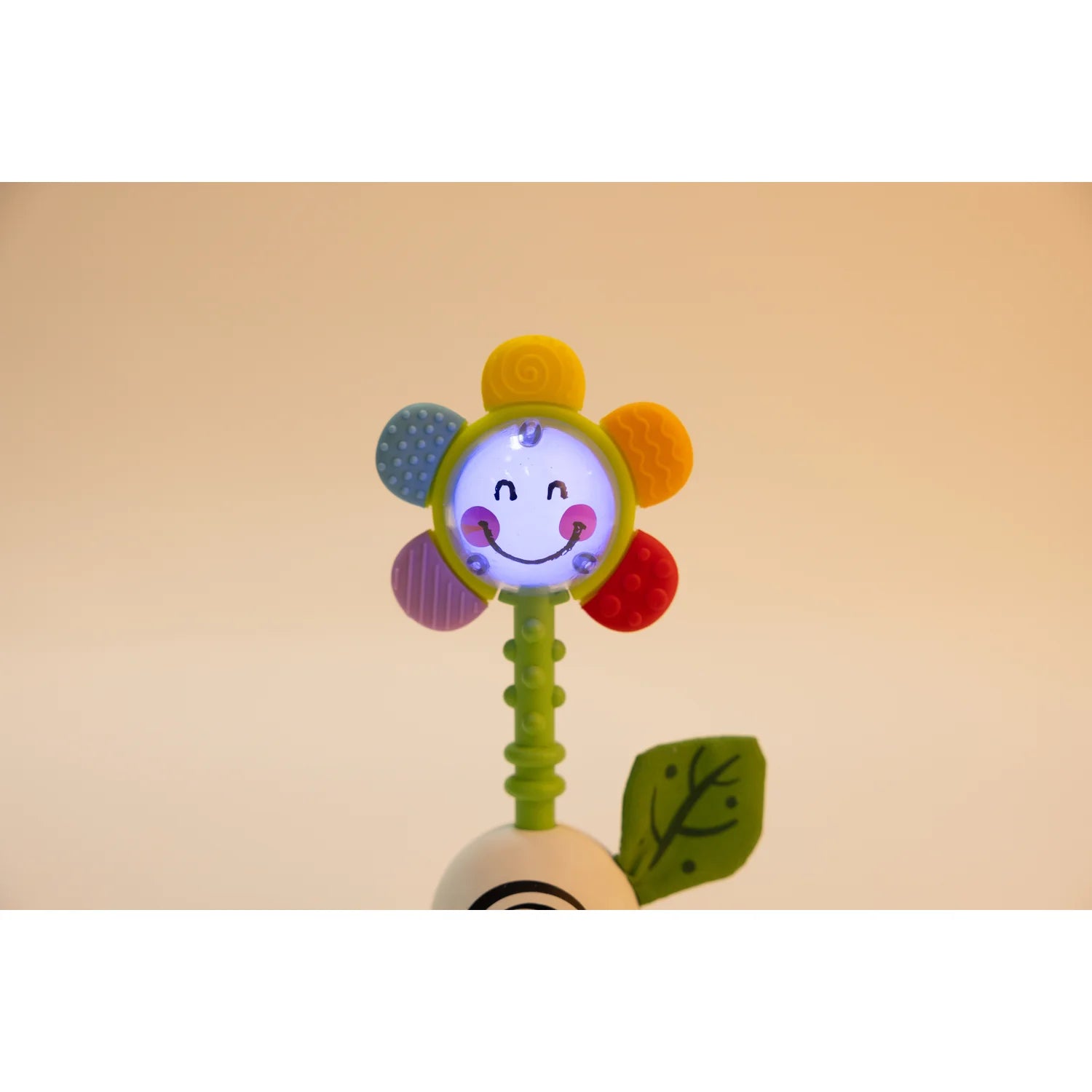 Colorful flower-shaped toy with a smiling face on a beige background
