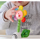 Child holding a colorful flower-shaped toy with a smiling face.