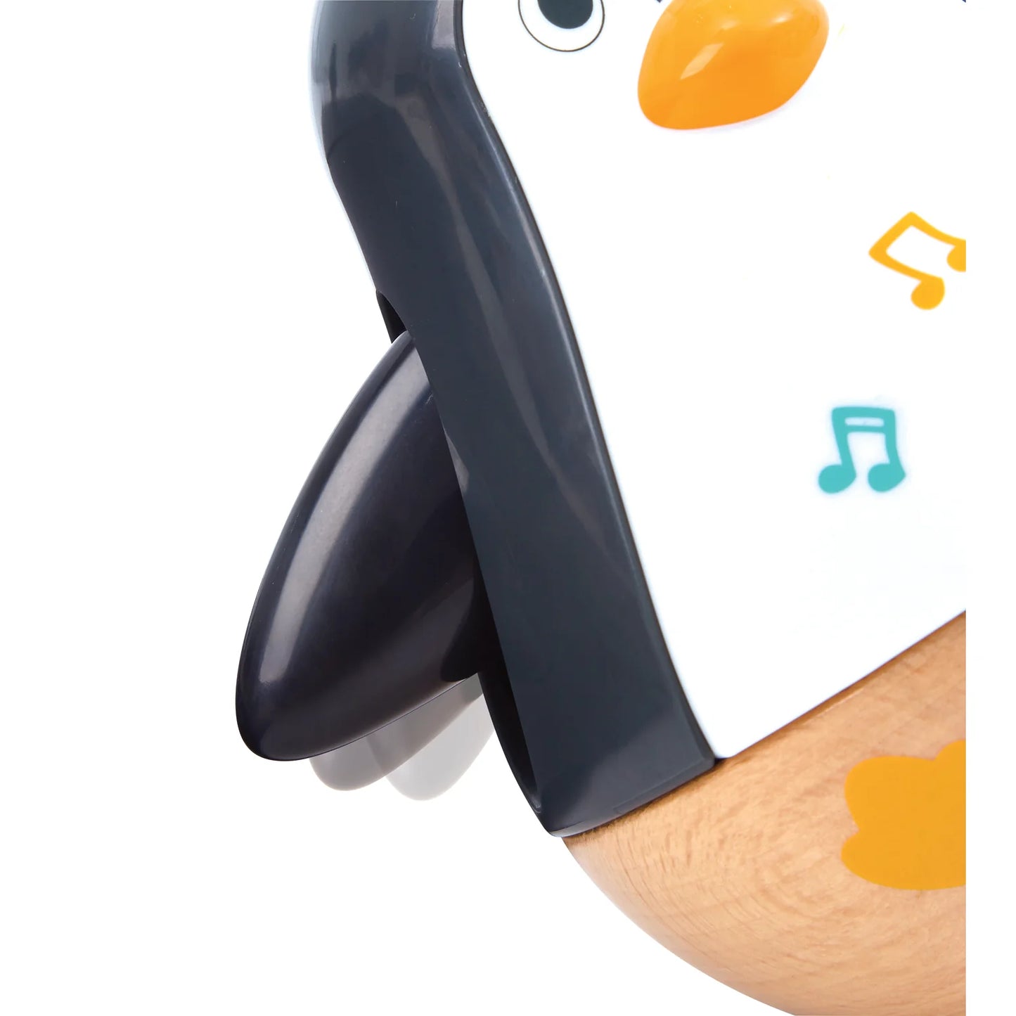 Close-up of a penguin-shaped toy with musical notes on a white background